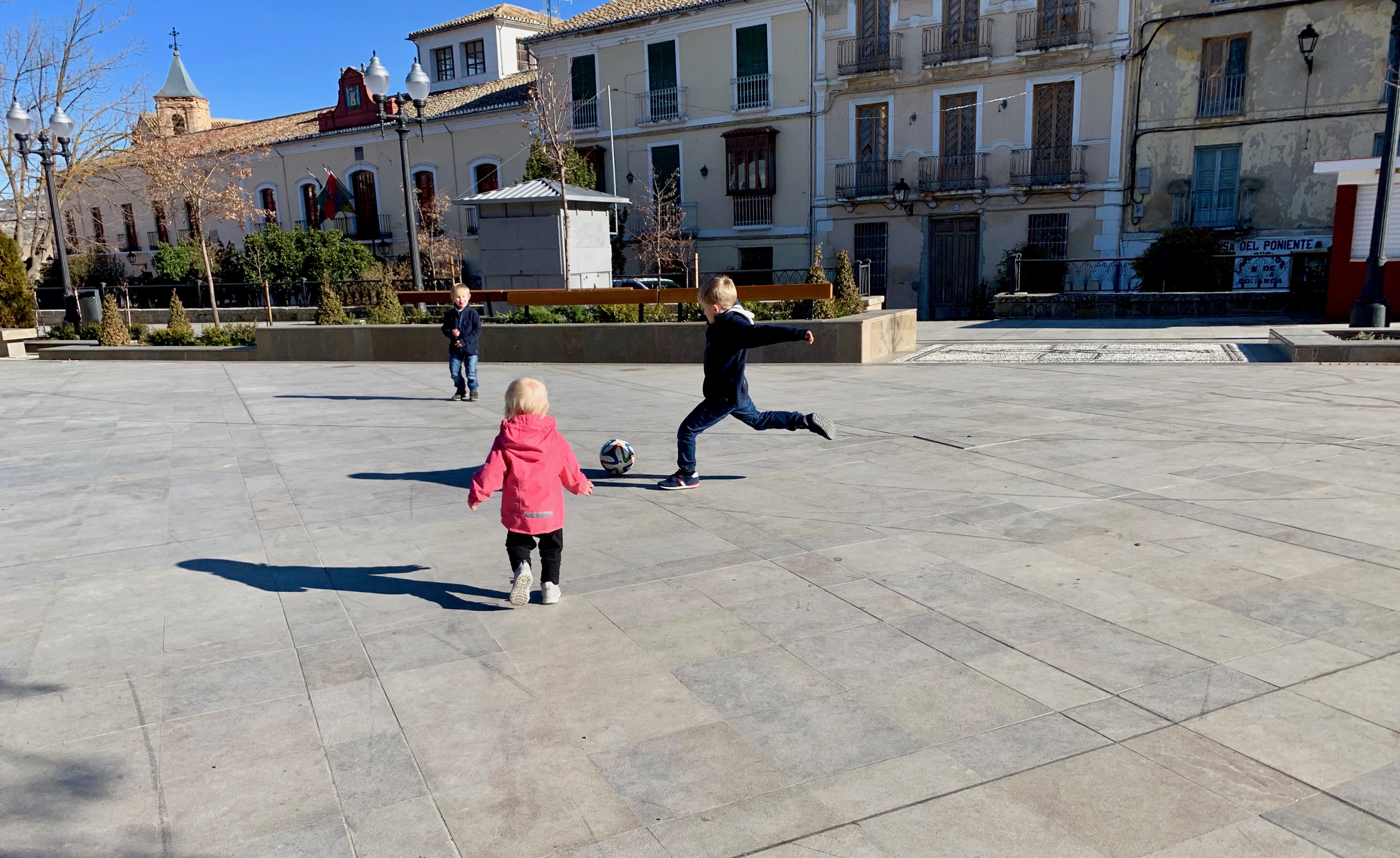 Barnen spelar fotboll på torget i Alhama de Granada